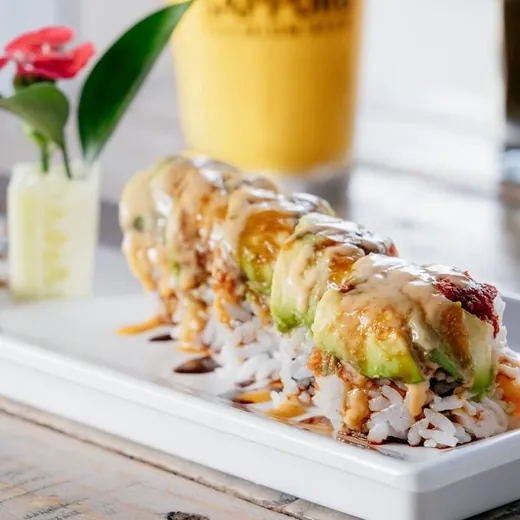 Roll topped with avocado and sauce