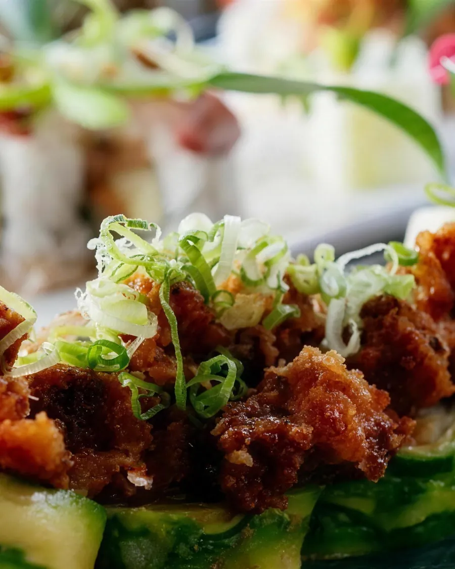 Avocado-wrapped roll with crispy topping and green onion